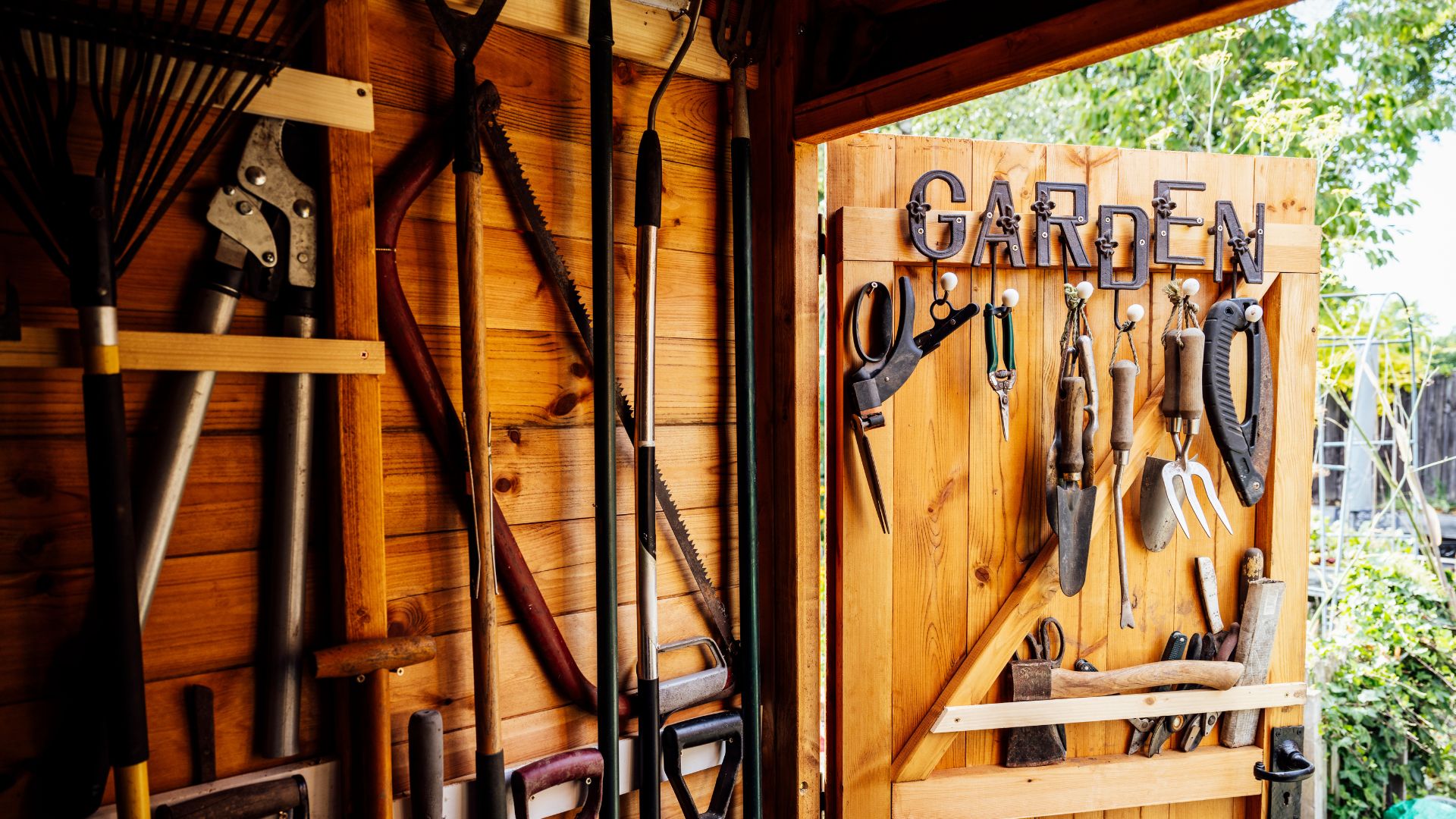 picture of wooden shed with tools organised and hung up on the wall and door