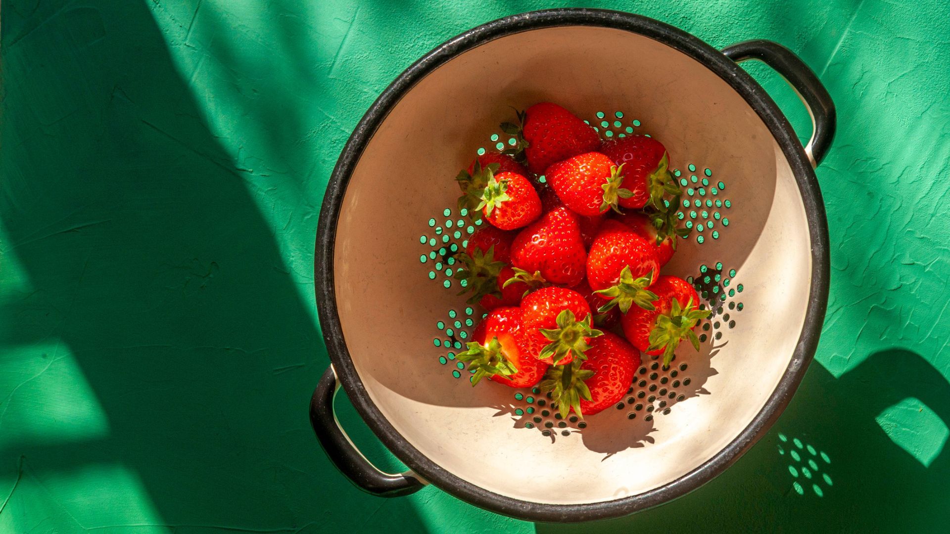 Strawberries in colander in the sunshine