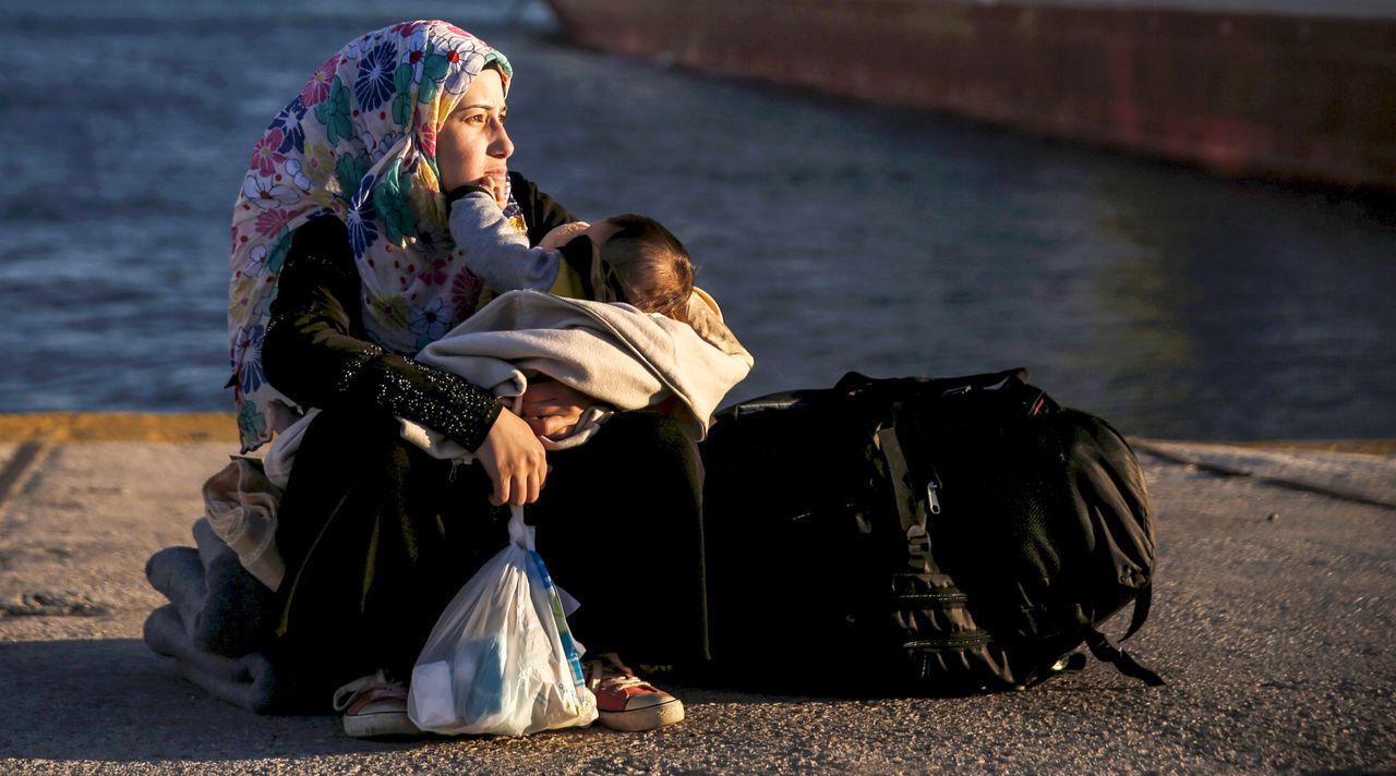 A Syrian refugee holds her baby after arriving in Greece.