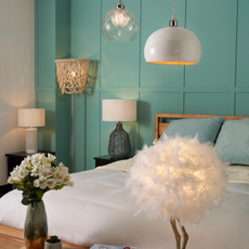 Photo of bed and blue wall with lighting fixtures