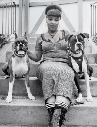 Black and white photo of woman with two dogs, on steps, from Rapper's Deluxe
