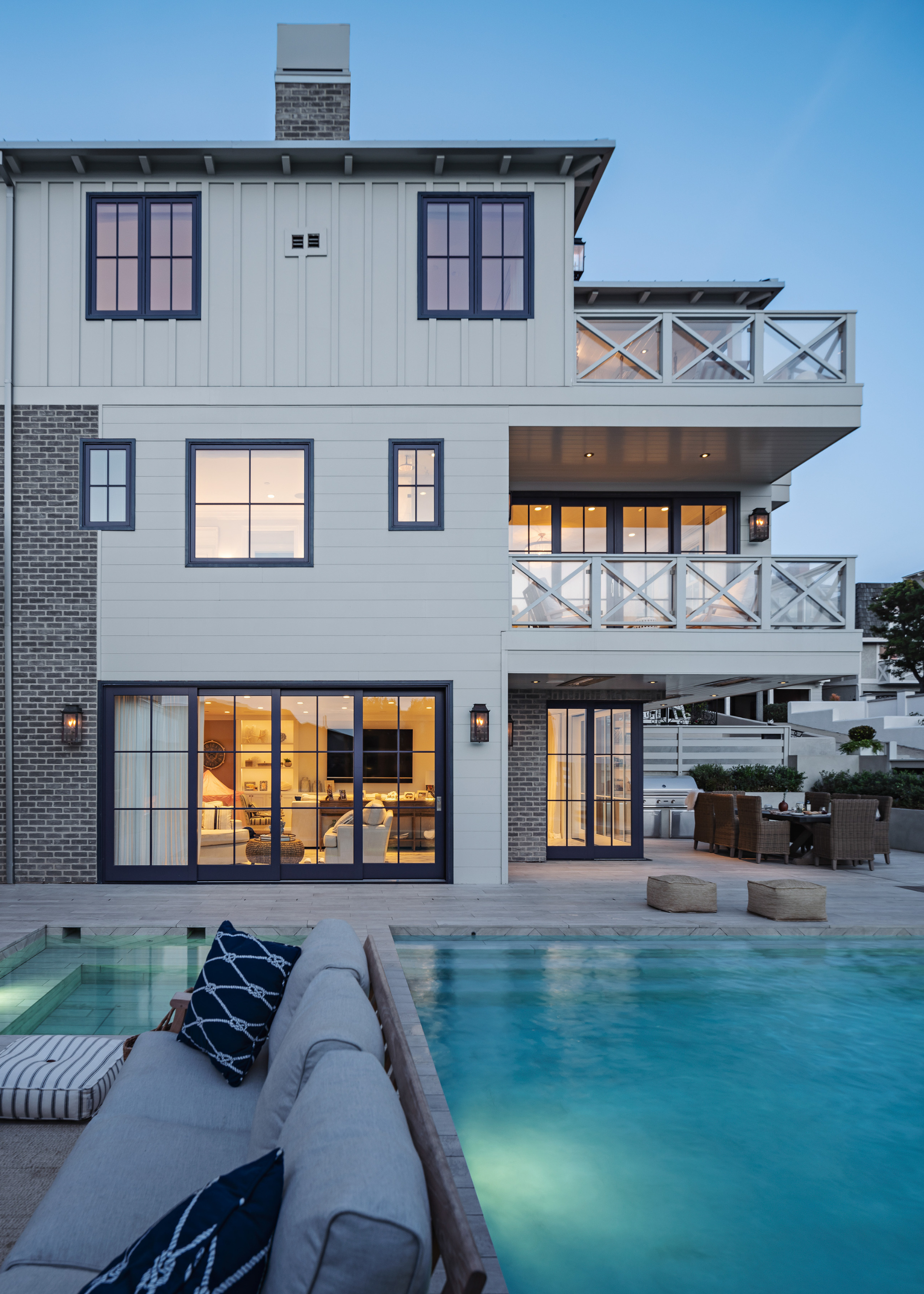 beautiful outdoor area at night with a large swimming pool and a seating area