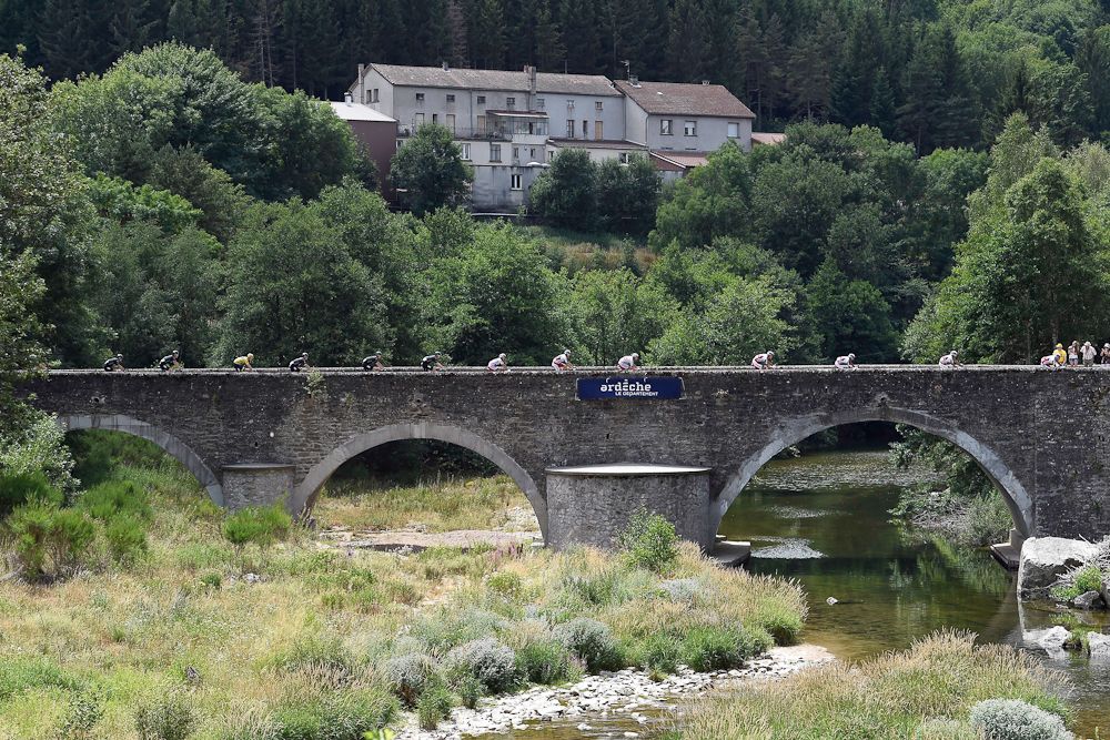 The peloton rolls over a bridge during stage 15.
