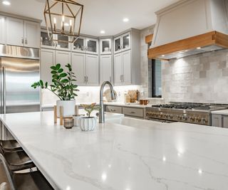 Natural white stone kitchen island within beautiful kitchen, with silver faucet by in-built sink copy