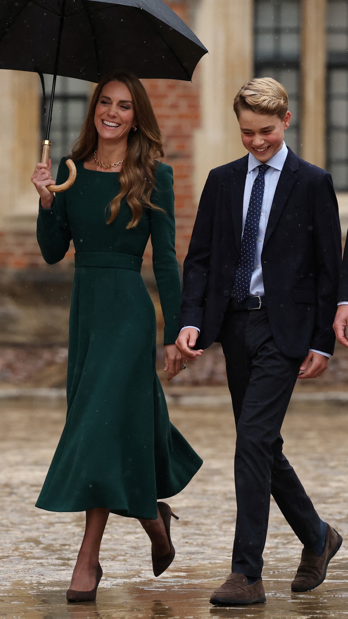 Catherine, Princess of Wales holds an umbrella and walks with Prince George as he arrives for his first day at Eton College