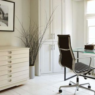 room with white wall and chest and chair and glass desk