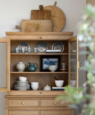 A kitchen cupboard decorated with antique silverware