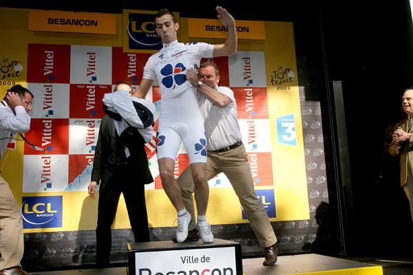 Bernard Hinault shoves a spectator off the podium.