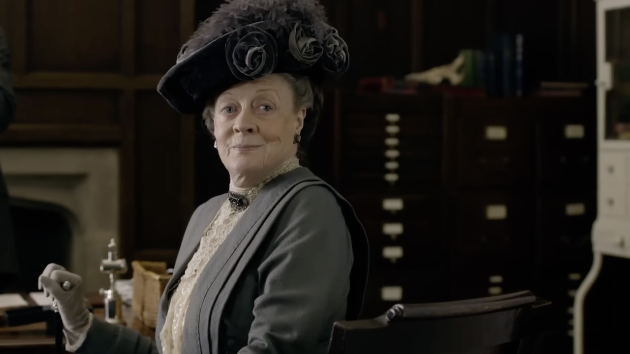 Maggie Smith as the Dowager Countess in Downton Abbey turning around in her chair and smirking 