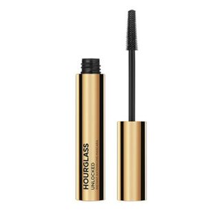 A gold opened Hourglass mascara tube and wand on a white background.