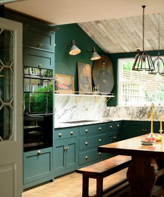 dark green kitchen with wooden ceiling and brass fixtures