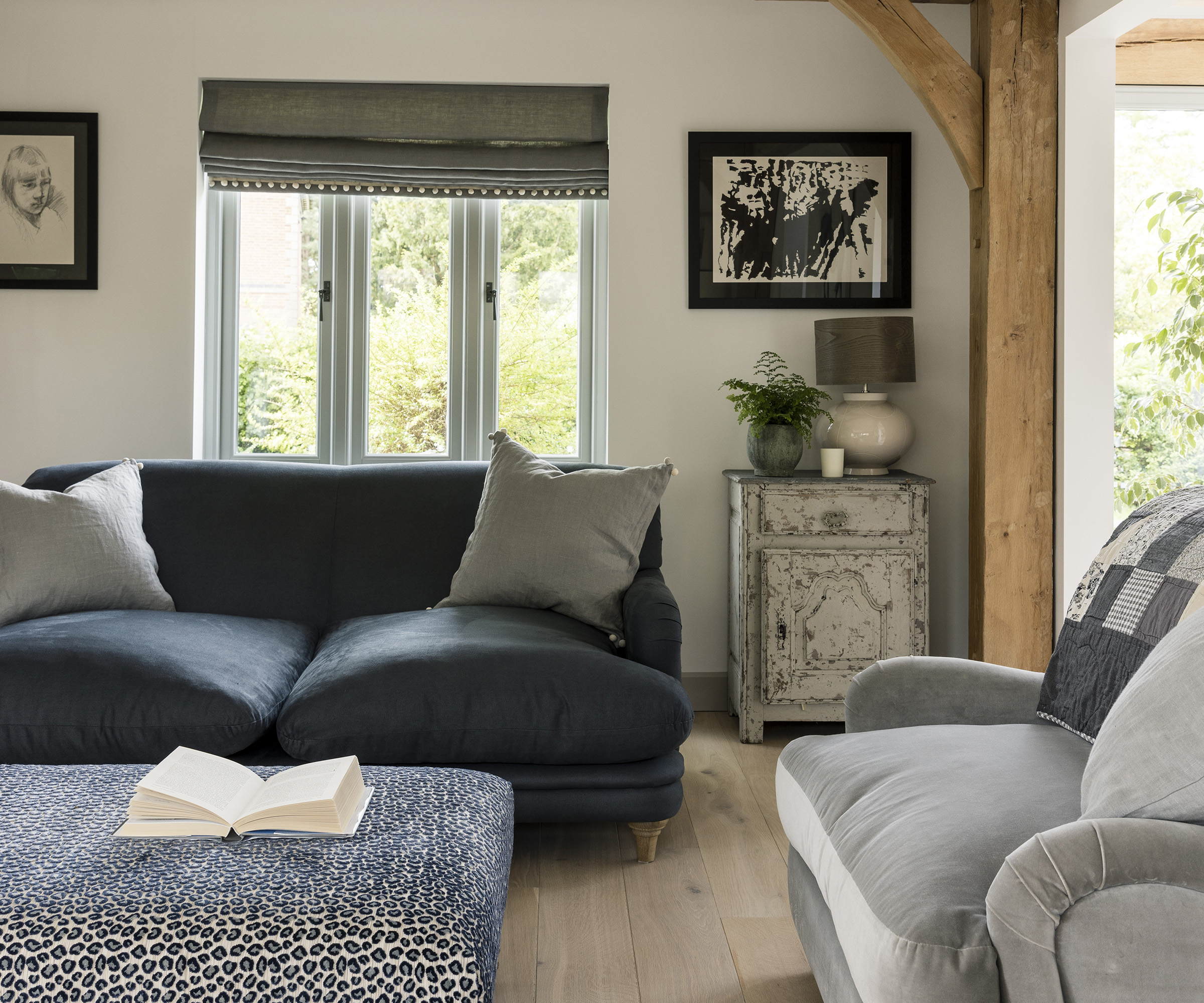 A cosy living room with exposed beams and neutral paint and decor