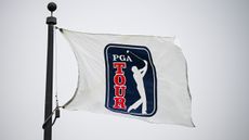 A white PGA Tour flag blows in the wind