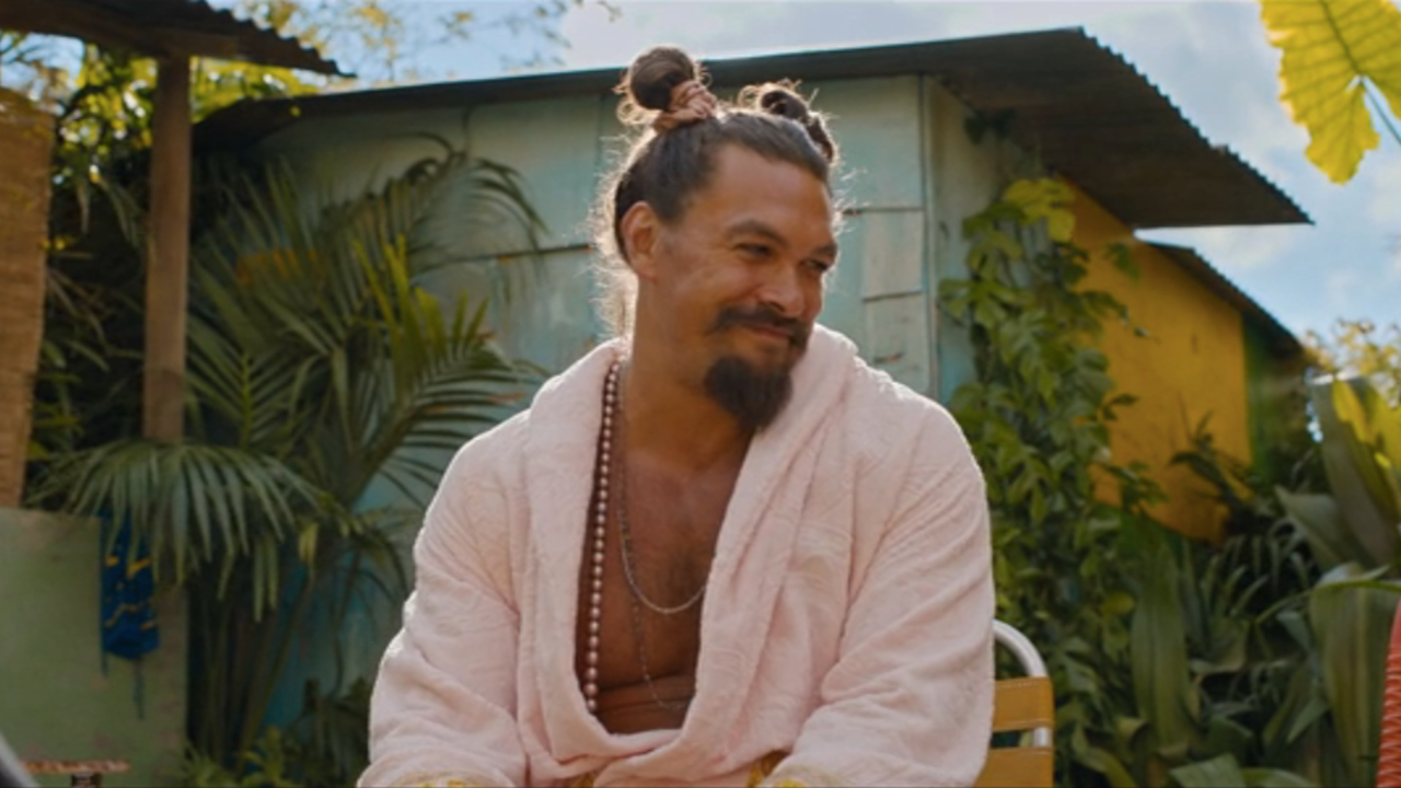Jason Momoa smiles as he sits in a sunny setting in Fast X.