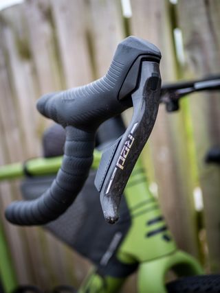 Detail photo of a green Ridley ASTR RS leaning against a wooden fence