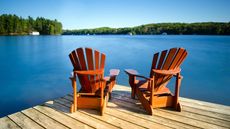 two adirondack chairs on dock overlooking lake