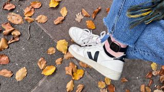 Grace Walsh wearing Fitbit on ankle with fall leaves on the ground to test the difference between wearing positions