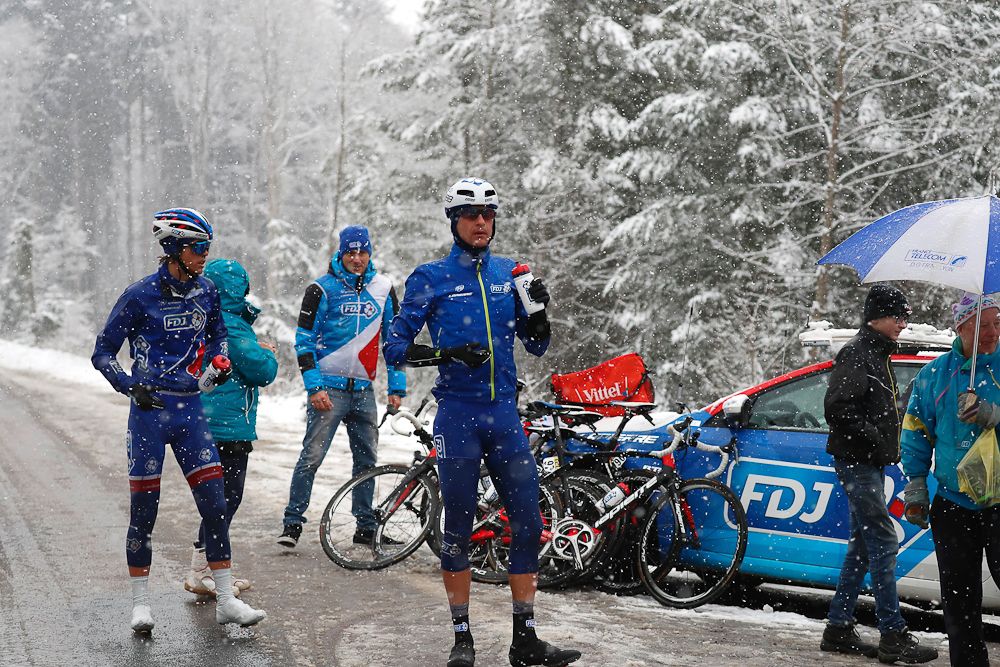Cyclists of FDJ team have a break under the snow during the third stage of the 74th edition of the Paris-Nice