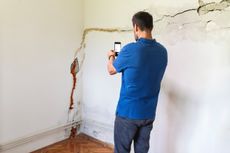 Mature man looking at a damaged wall