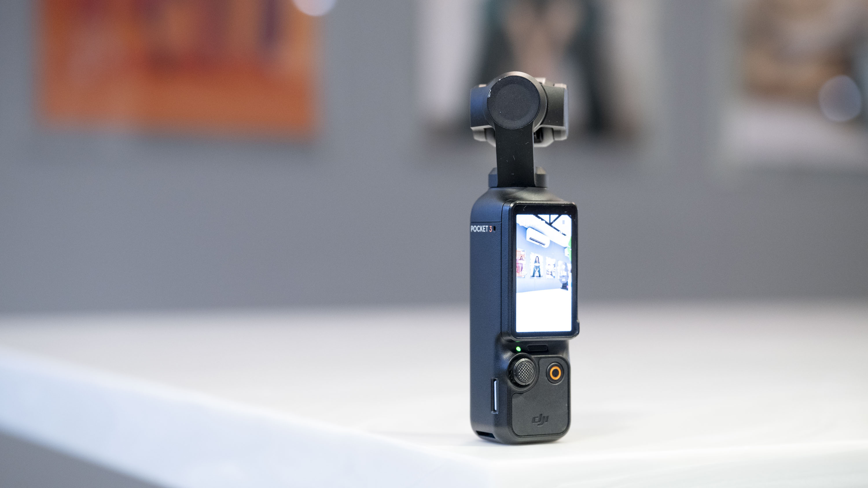 DJI Osmo Pocket 3 vlogging camera stood on a white marble-effect table