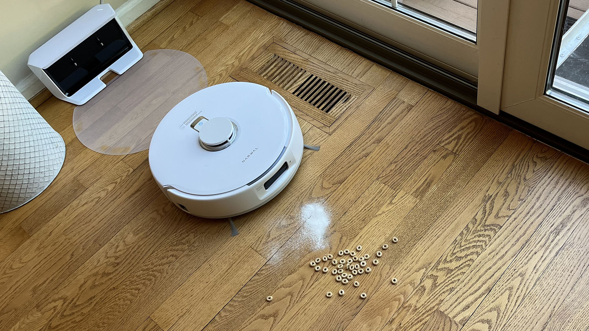 Narwal Freo X Plus robot vacuum and mop about to vacuum up piles of flour and cereal on hard floor