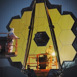 Large assembly of hexagonal gold mirrors with technicans inspecting