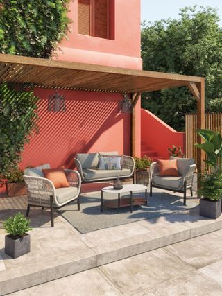 wooden pergola over patio with John Lewis outdoor seating and terracotta wall behind