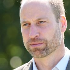 A headshot of Prince William looking serious and wearing a white dress shirt and gray blazer