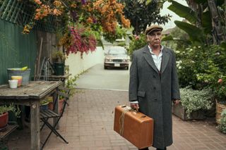 Paride Benassai as Giacomo Ortolano carrying a suitcase