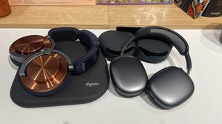 The Dyson OnTrac and Apple AirPods Max headphones lying on top of their respective cases.