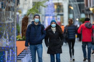 Two people walking down the road wearing a face mask in England as we may go back into lockdown again