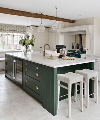 A white kitchen with dark green cabinetry and an Aga