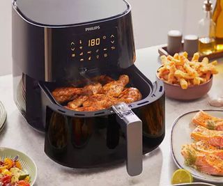 Philips Essentials XL Air Fryer on a kitchen counter, filled with air-fried food.