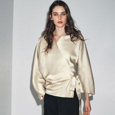 model wears wrap top from Zara and black curved pants