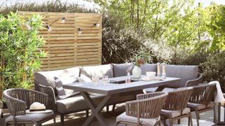 wooden fence with fairy lights on patio with grey outdoor furniture