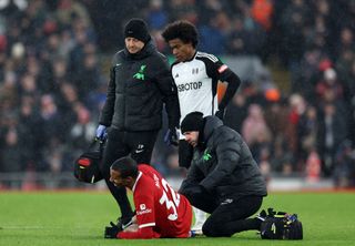 Joel Matip of Liverpool receives medical treatment during the Premier League match between Liverpool FC and Fulham FC at Anfield on December 03, 2023 in Liverpool, England.