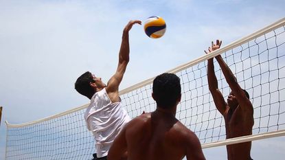 Men playing beach volleyball