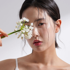 An image featuring an Asian woman holding a flower