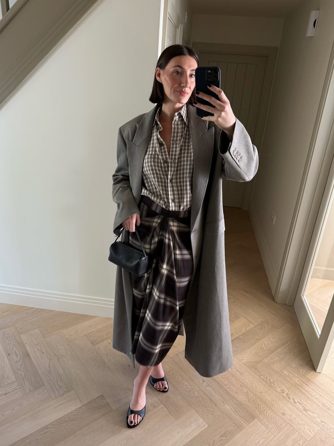 @sarahlouiseblythe wears flannel shirt and checked skirt and grey coat