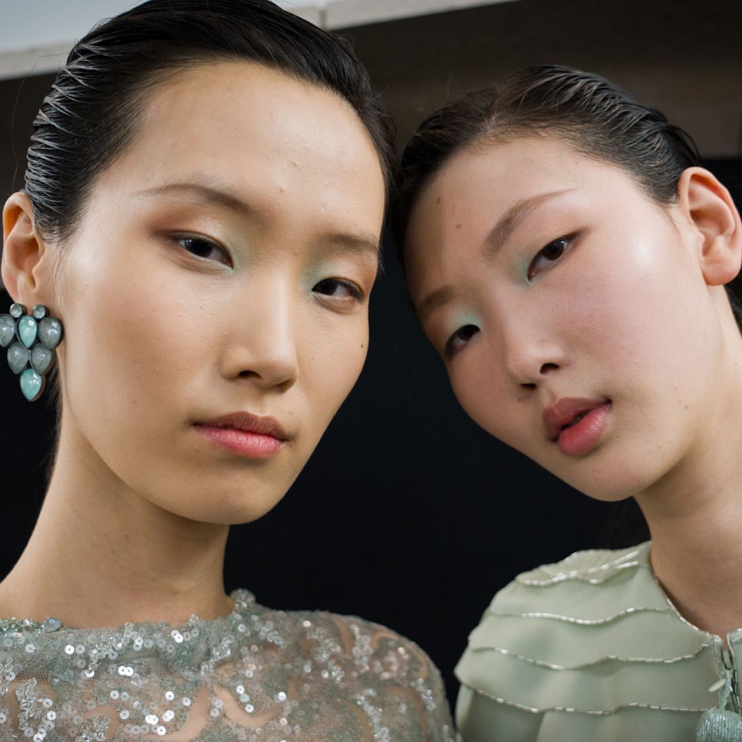 Two models with glowy, highlighted skin. 