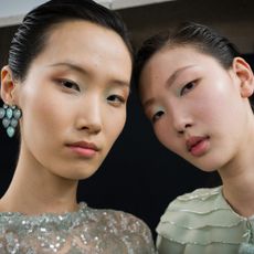 Two models with glowy, highlighted skin. 