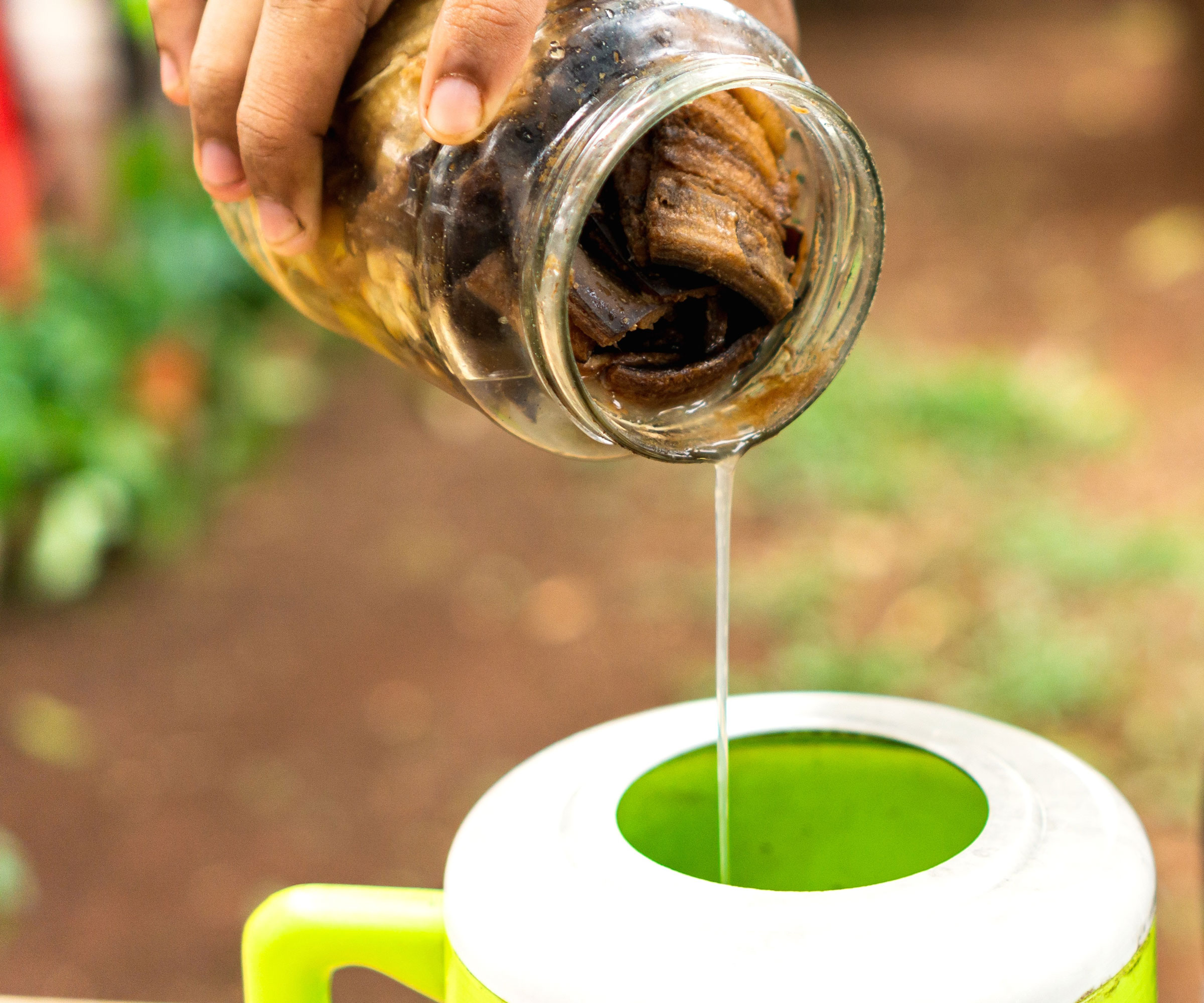pouring banana liquid into yellow watering can