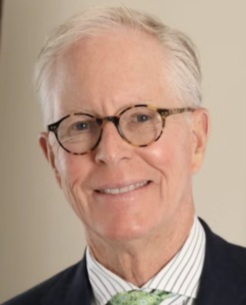 a white man with white hair and glasses in a shirt and tie