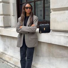 Influencer Lorna Symphony wearing a blazer, jeans with a Celine bag beside her