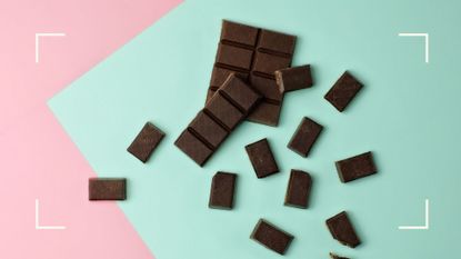 Bar of dark chocolate broken into pieces, scattered across colorful background to represent how to stop eating chocolate