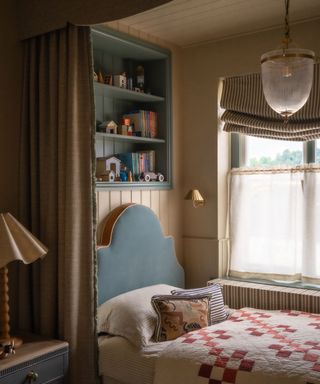 cozy bedroom nook with a canopy bed and eclectic yellow and blue color palette with a patchwork quilt