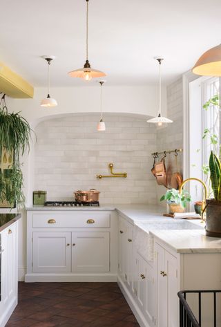 a kitchen with multiple pendant lights throughout the space