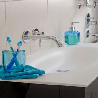 bathroom with wall mounted basin mixer and hand wash bottle