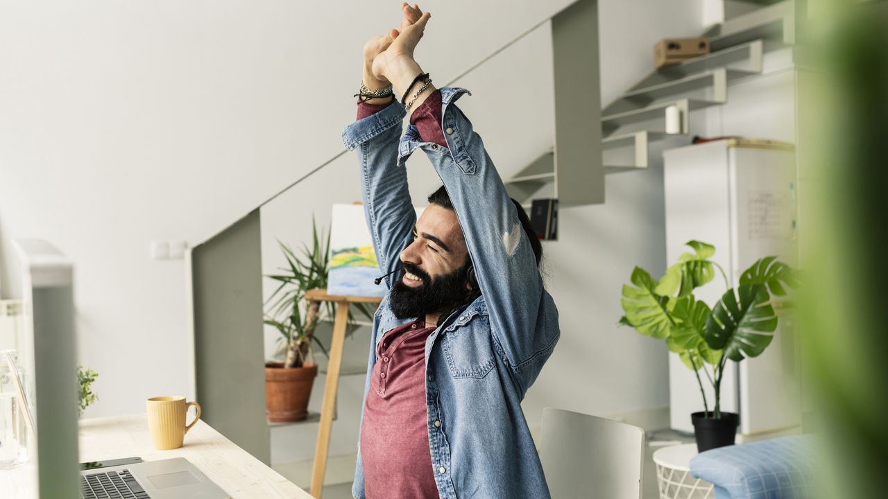 Man stretching in office chair