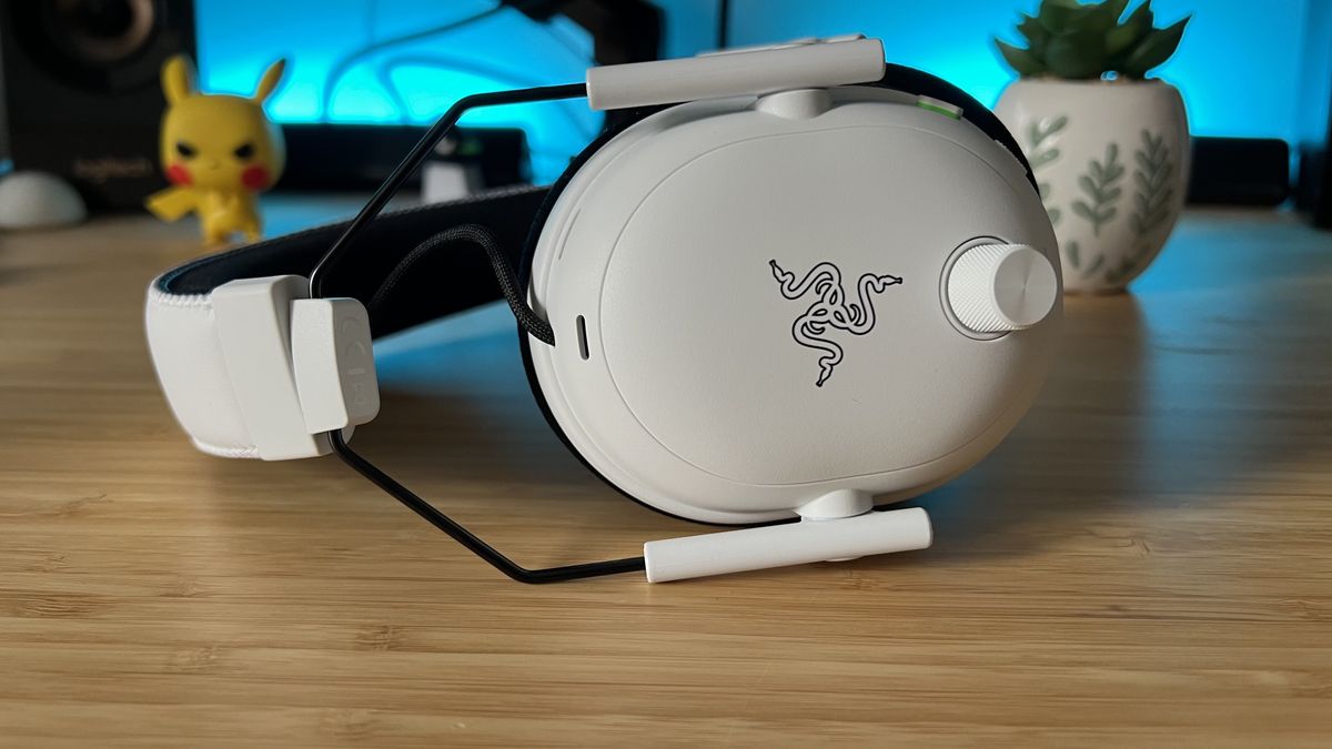 Razer BlackShark V3 Pro gaming headset on its side on a wooden desk